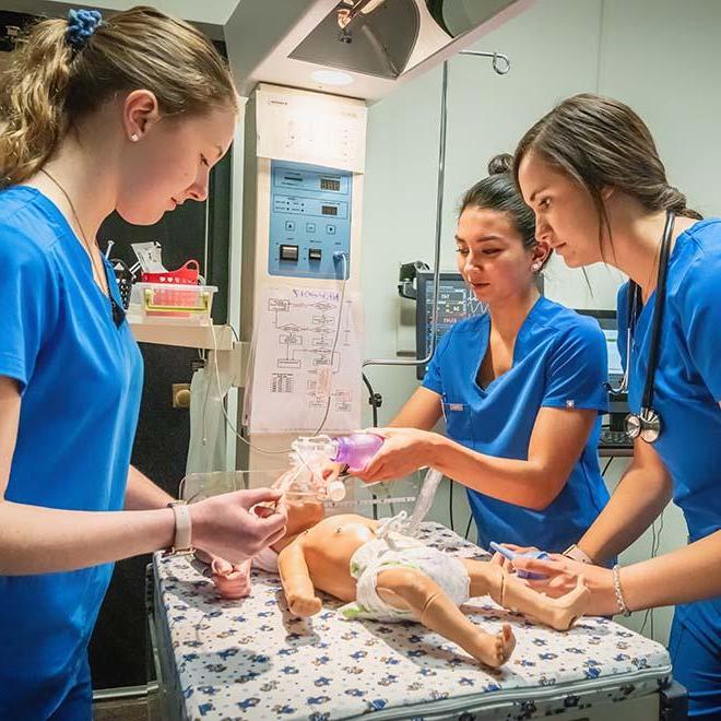 三名护生正在给婴儿假人做呼吸治疗